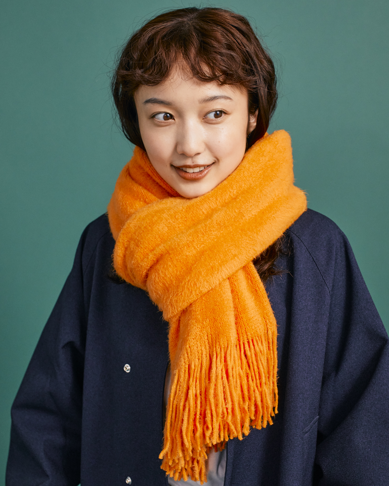 オレンジのマフラーで色差し。いつものコートに華やかさを添える