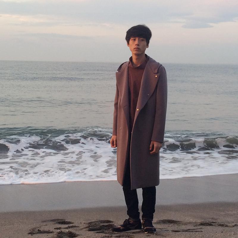 夜明けの海辺に立つ坂口健太郎さん。着用しているのは、今シーズンの